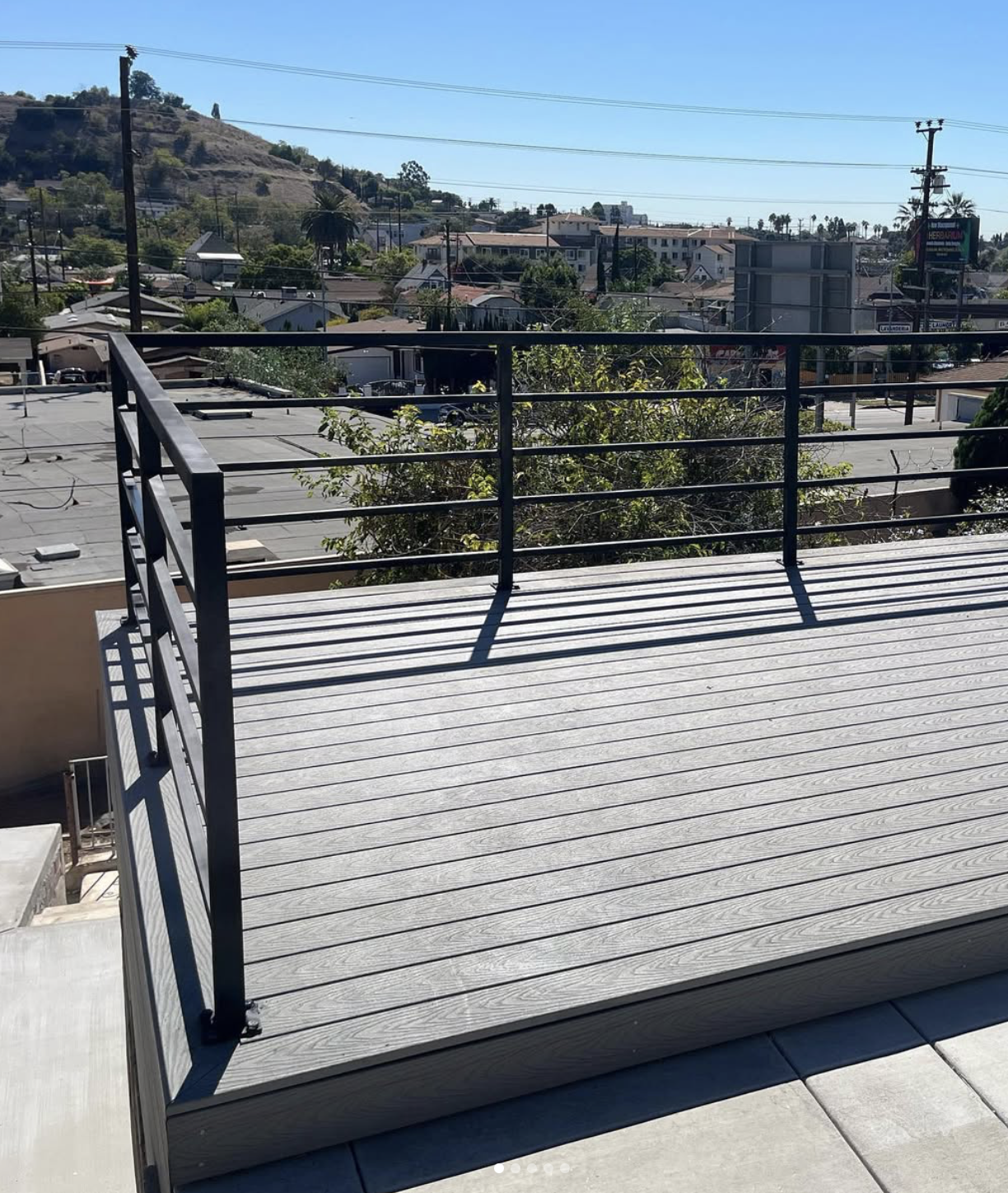 Completed outdoor project featuring modern black metal railing and finished deck platform