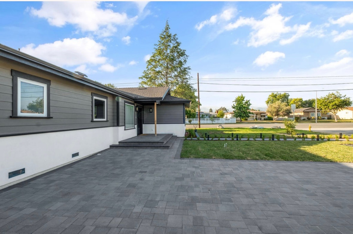 Completed gray paver driveway and front entry hardscape at a modern Southern California home
